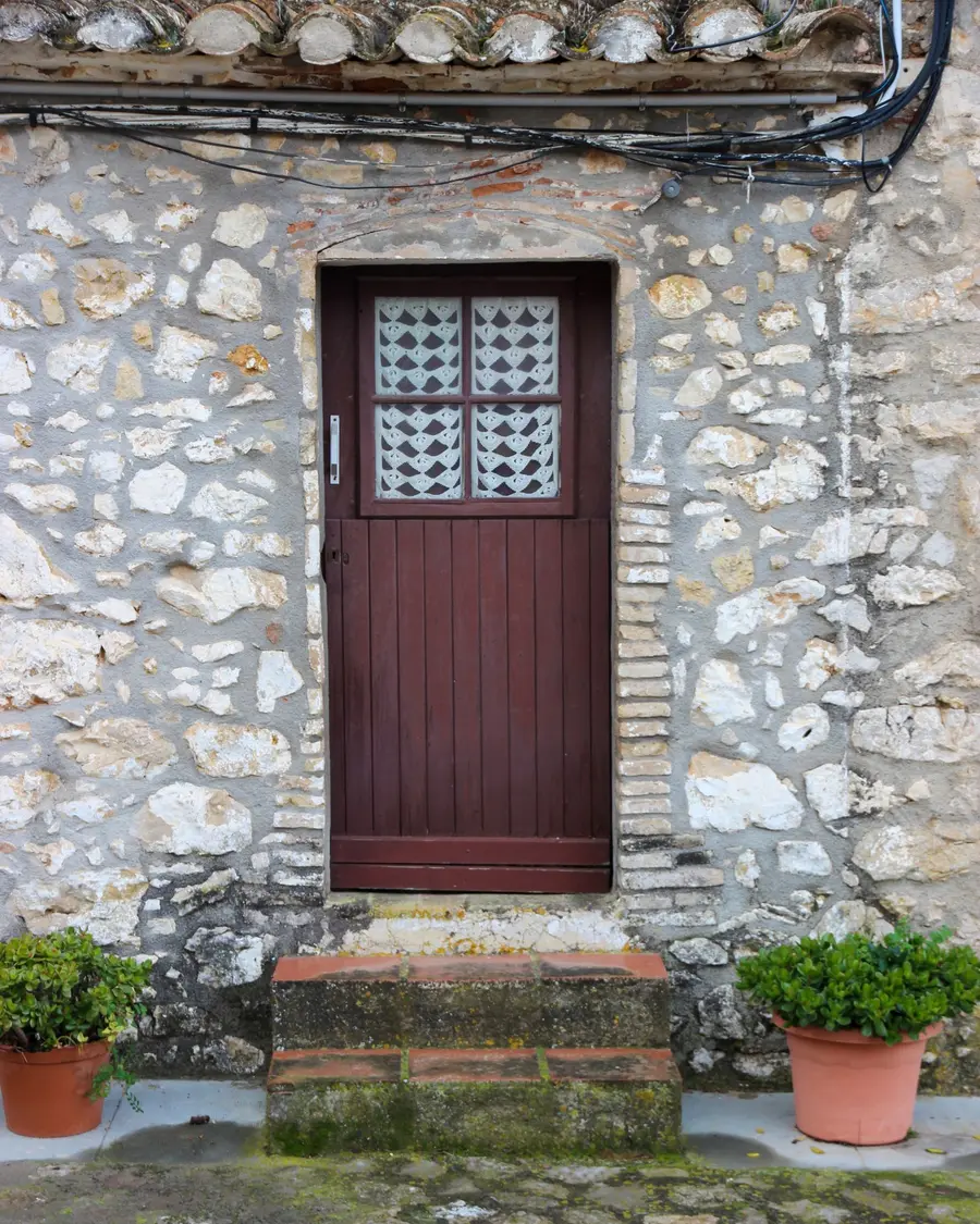 Porte d'entrée en bois sur une façade en pierre