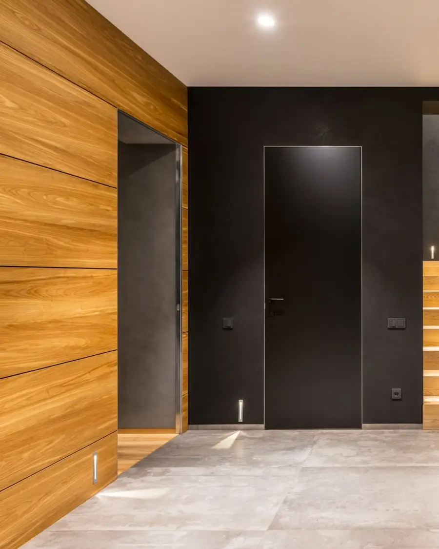 Couloir avec habillage bois et porte intérieure noire