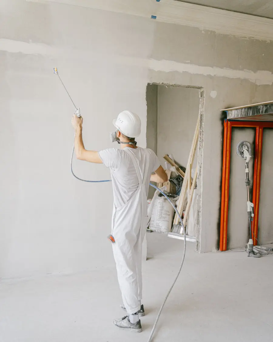 Ouvrier réalisant des travaux de finition dans un logement en rénovation